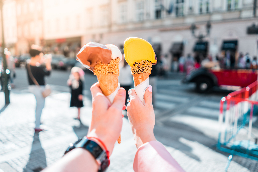 a couple holding ice creams with a busy street in the background - a Picjumbo image.