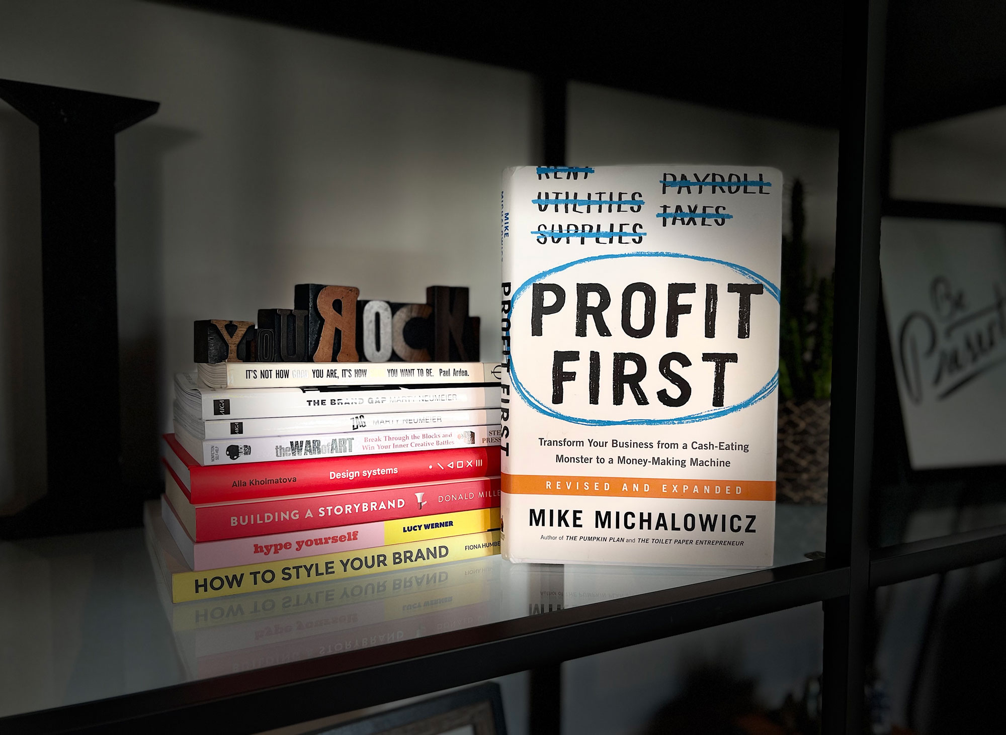 The book Profit First on a shelf with some other books
